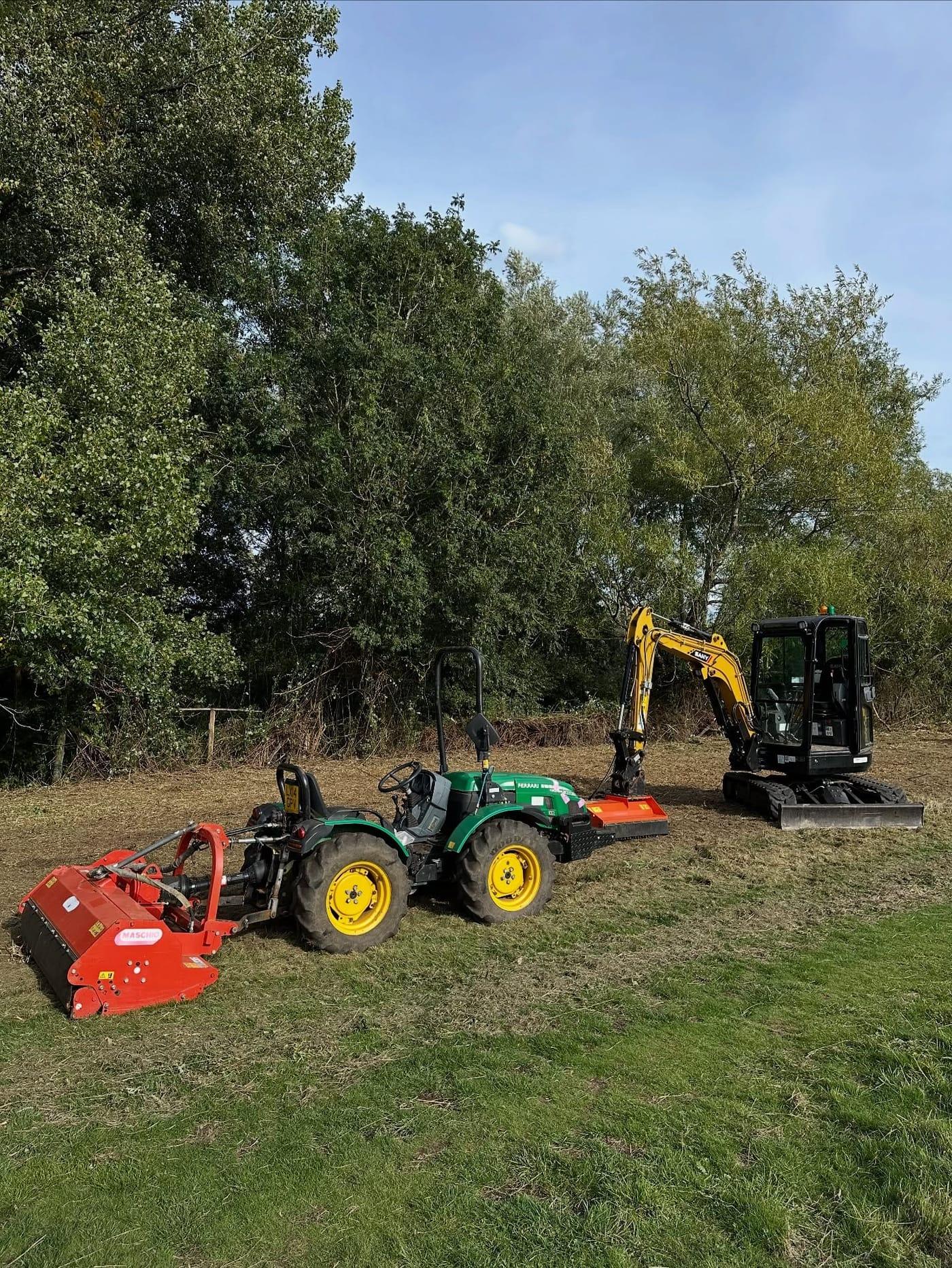 Compact tractor with a flail mower alongside a mini excavator on site